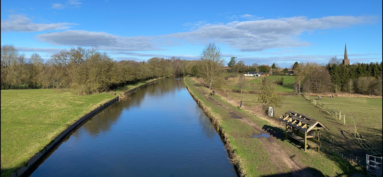 An image taken above a canal, surrounded by countryside